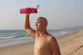 A bald, handsome man with a naked or bare torso watering himself Royalty Free Stock Photo