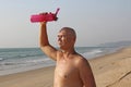 A bald, handsome man with a naked or bare torso watering himself with water from a pink fitness bottle. The man is thirsty. Heat Royalty Free Stock Photo