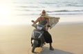 A bald-headed man rides on a scooter along the seashore or the b Royalty Free Stock Photo