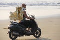 A bald-headed man rides on a scooter along the seashore or the b Royalty Free Stock Photo