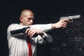 Bald hired killer in red tie aims a pistols Royalty Free Stock Photo