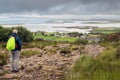 Bald male tourist with backpack looking at beautiful scenery. Westport, county Mayo, Ireland. Foot path to Croagh Patrick. Irish