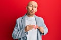 Bald man with beard holding broken heart paper shape looking at the camera blowing a kiss being lovely and sexy Royalty Free Stock Photo