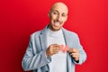 Bald man with beard holding broken heart paper shape smiling with a happy and cool smile on face Royalty Free Stock Photo