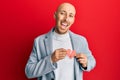 Bald man with beard holding broken heart paper shape smiling and laughing hard out loud because funny crazy joke Royalty Free Stock Photo