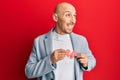 Bald man with beard holding broken heart paper shape smiling looking to the side and staring away thinking Royalty Free Stock Photo