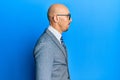 Bald man with beard wearing business jacket and glasses looking to side, relax profile pose with natural face with confident smile Royalty Free Stock Photo