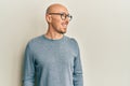 Bald man with beard wearing casual clothes and glasses looking to side, relax profile pose with natural face and confident smile Royalty Free Stock Photo