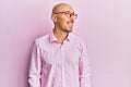 Bald man with beard wearing casual clothes and glasses looking to side, relax profile pose with natural face and confident smile Royalty Free Stock Photo