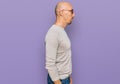 Bald man with beard wearing casual clothes and glasses looking to side, relax profile pose with natural face with confident smile Royalty Free Stock Photo