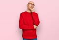 Bald man with beard wearing casual clothes and glasses serious face thinking about question with hand on chin, thoughtful about Royalty Free Stock Photo