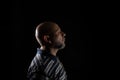 Bald man with beard wearing a casual shirt over black background, full of Thoughts Royalty Free Stock Photo