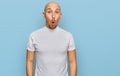 Bald man with beard wearing casual white t shirt afraid and shocked with surprise expression, fear and excited face Royalty Free Stock Photo