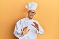 Bald man with beard wearing professional cook uniform disgusted expression, displeased and fearful doing disgust face because
