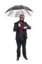 A bald man in glasses with a beard under an opened black umbrella. Dressed in a formal suit. Isolated over white background. Royalty Free Stock Photo