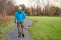 Bald man in his 40s walking on a path in a park with Yorkshire terrier on a leash. Concept animal care and outdoor activity, Royalty Free Stock Photo
