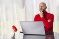 Bald man in his 40s working home on note book.. Model in red shirt with grey beard. Home office work. Programmer at work. Back Royalty Free Stock Photo