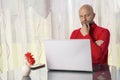 Bald man in his 40s working home on note book.. Model in red shirt with grey beard. Home office work. Programmer at work. Back Royalty Free Stock Photo