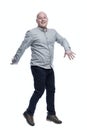 A bald man jumps funny. A 40-year-old guy wearing a gray shirt and dark blue jeans. Humor and positivity. Isolated on a white Royalty Free Stock Photo