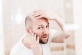 Bald man looking mirror at head baldness and hair loss Royalty Free Stock Photo