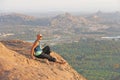 A bald man looks at the sunset at Hampi. Top Hampi. A man sits on top of a mountain and looks into the distance. Meditation, rest