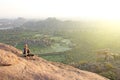 A bald man looks at the sunset at Hampi. Top Hampi. A man sits on top of a mountain and looks into the distance. Meditation, rest