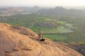 A bald man looks at the sunset at Hampi. Top Hampi. A man sits on top of a mountain and looks into the distance. Meditation, rest