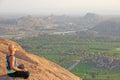 A bald man looks at the sunset at Hampi. Top Hampi. A man sits on top of a mountain and looks into the distance. Meditation, rest