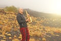 A bald man plays on a gold alto saxophone in the nature, against Royalty Free Stock Photo