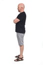 Bald man in profile with shirt shorts and sandals, arms crossed Royalty Free Stock Photo