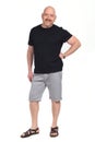 Bald man with sandals t-shirt and shorts, hand on hip looking at camera on whithe background Royalty Free Stock Photo