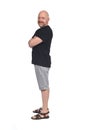 Bald man with sandals t-shirt and shorts, side view arms crossed Royalty Free Stock Photo