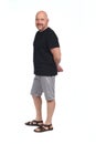 Bald man with sandals t-shirt and shorts, side view hands crossed Royalty Free Stock Photo