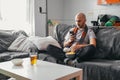 Young man looking at phone watching sports on the sofa Royalty Free Stock Photo