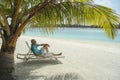 Bald man on a sun lounger under a palm tree in the Maldivian b Royalty Free Stock Photo