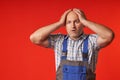 Bald man holds his head with his hands and looks forward with a frightened look Royalty Free Stock Photo