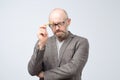 Bald mature european man is thinking about something with pencil. How to solve this problem Royalty Free Stock Photo