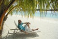 Bald men on a sun lounger under a palm tree in the Maldivian b Royalty Free Stock Photo