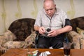 Bald Old Man Checking Medicines with BP Apparatus