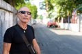 Bald senior tourist man thinking while wearing sunglasses agains Royalty Free Stock Photo