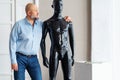 Bald serious adult man with beard, holding shoulders plastic black manikin Royalty Free Stock Photo