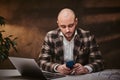 Bald european businessman sitting in the office at a table with notebook, wearing elegant jacket, shirt. Royalty Free Stock Photo