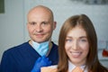 A smiling young woman with her bald middle-aged dentist in a dentist`s office Royalty Free Stock Photo