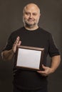 Bald middle-aged man with a sign in his hands, dark background Royalty Free Stock Photo