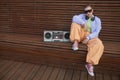 Bald tough girl posing with boombox sitting on bench in urban city setting Royalty Free Stock Photo