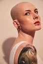 Bald unladylike woman with patches under her eyes posing with serious emotions