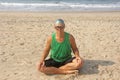 A bald and unusual young man, a freak, with a shiny bald head and round wooden glasses on the background of the beach and the sea