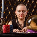 A bald woman fortune-teller is engaged in esotericism in a magic salon. Royalty Free Stock Photo