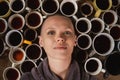 Bald woman surrounded by many cups of coffee. Concept of wakefulness, overwork, burnout at work