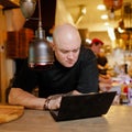 Bald young man looking at laptop